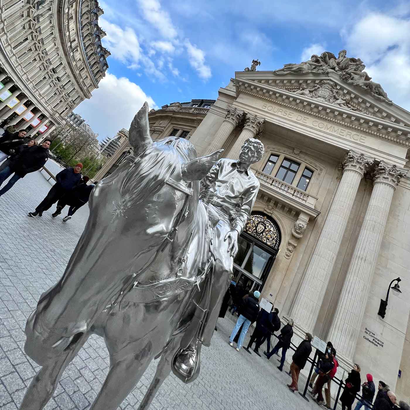 Glänzende Skulptur eines Reiters vor einem historischen Gebäude