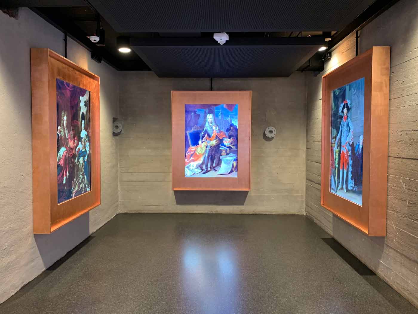 Ausstellungsraum mit drei wuchtigen digitalen Bilderrahmen mit Bildern von Kurfürsten