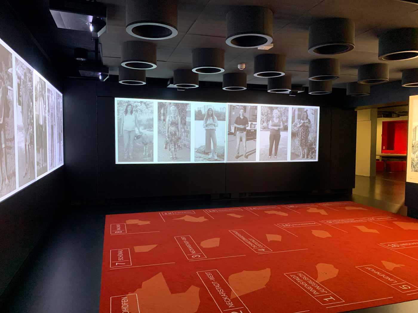 interaktive Ausstellung mit Zonen auf einem Teppich, Videoprojektionen und Lautsprechern