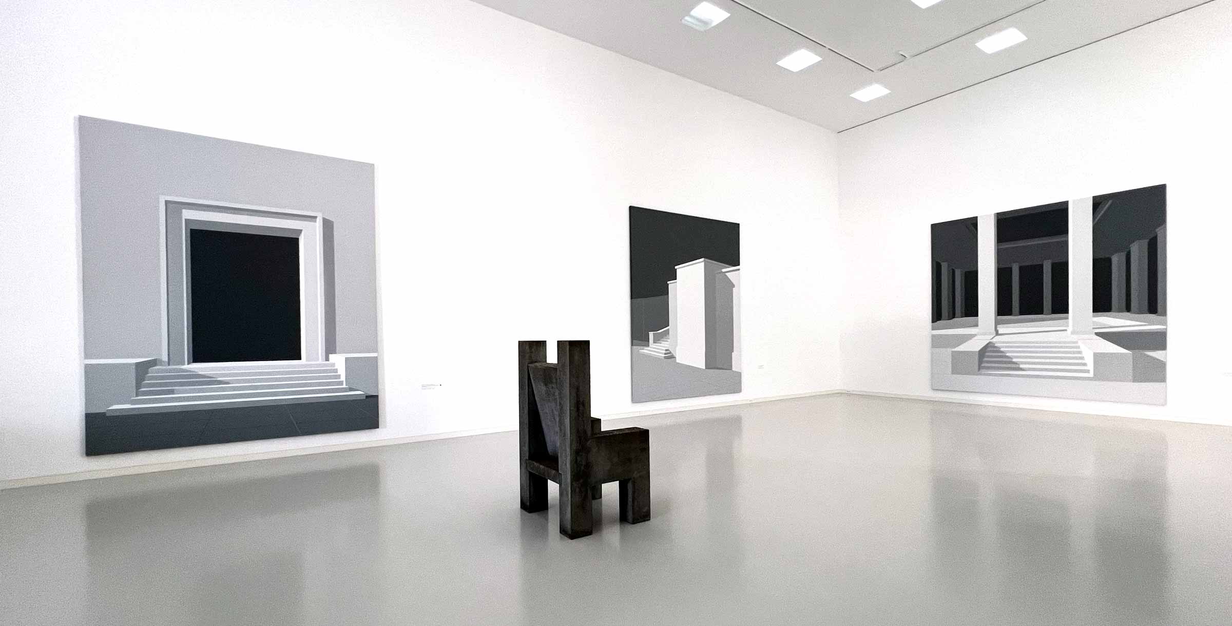 Ausstellungsraum mit NS-Architektur-Gemälden und einer Skulptur