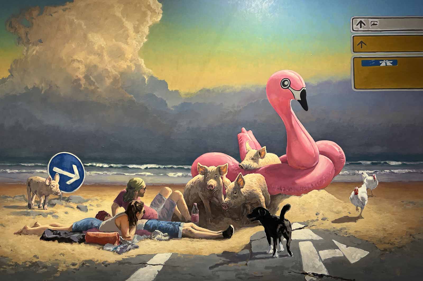 skurriles Bild einer Strandszene mit gigantischem Aufblasflamingo und Wildschweinen